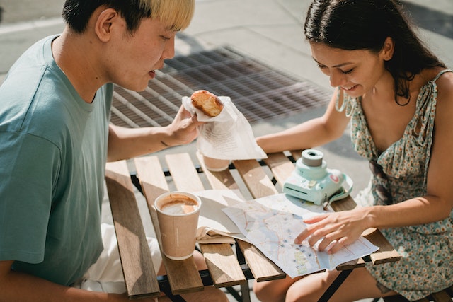 two people looking at a map over a cup of coffee