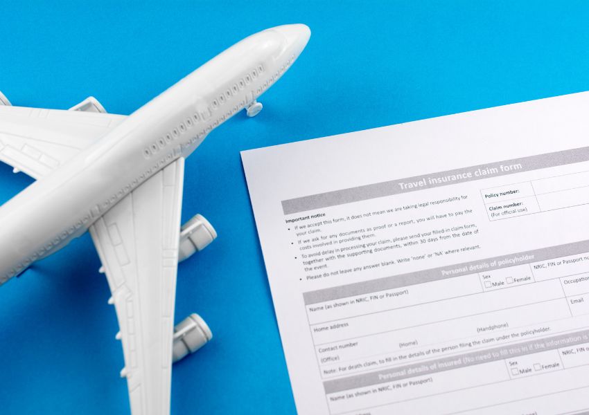airplane figurine next to travel insurance document