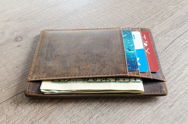 small brown wallet with cards and cash
