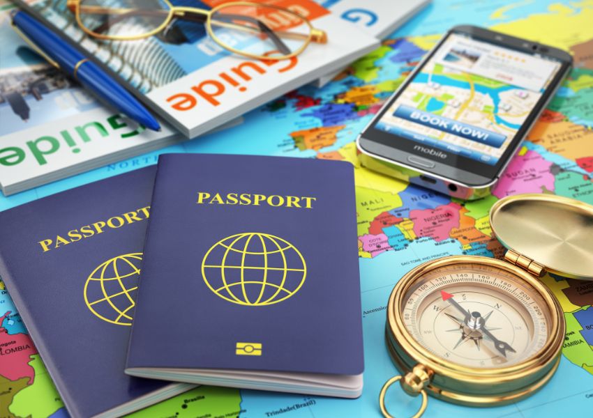 two passports sitting on tops of maps and guidebooks next to a compass